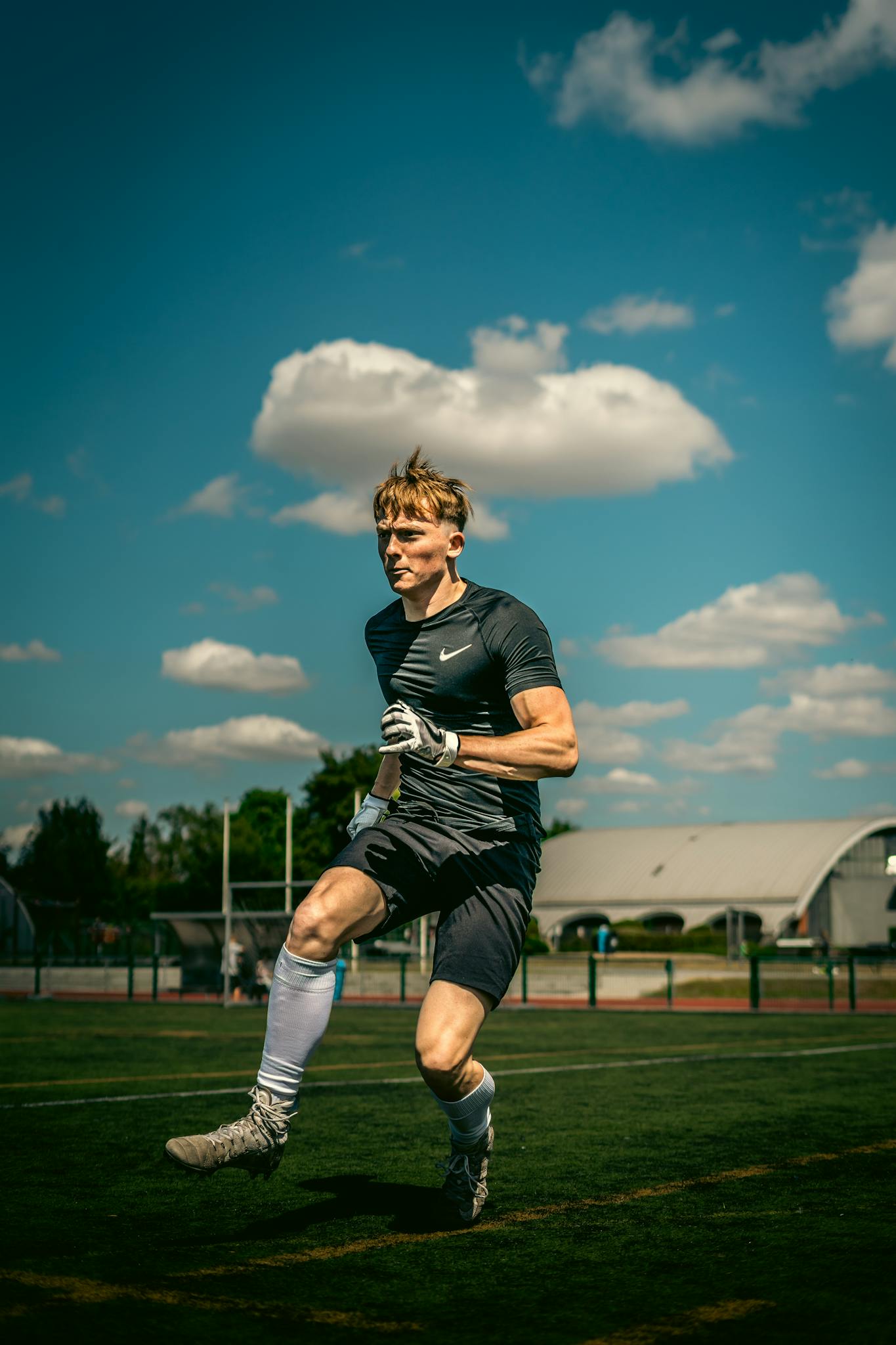 Caucasian male athlete training outdoors, exhibiting focus and energy under a bright sky.